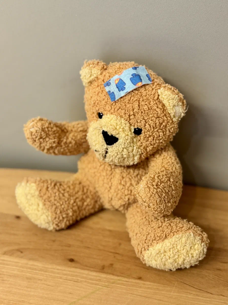 Teddybär mit einem Pflaster auf der Stirn